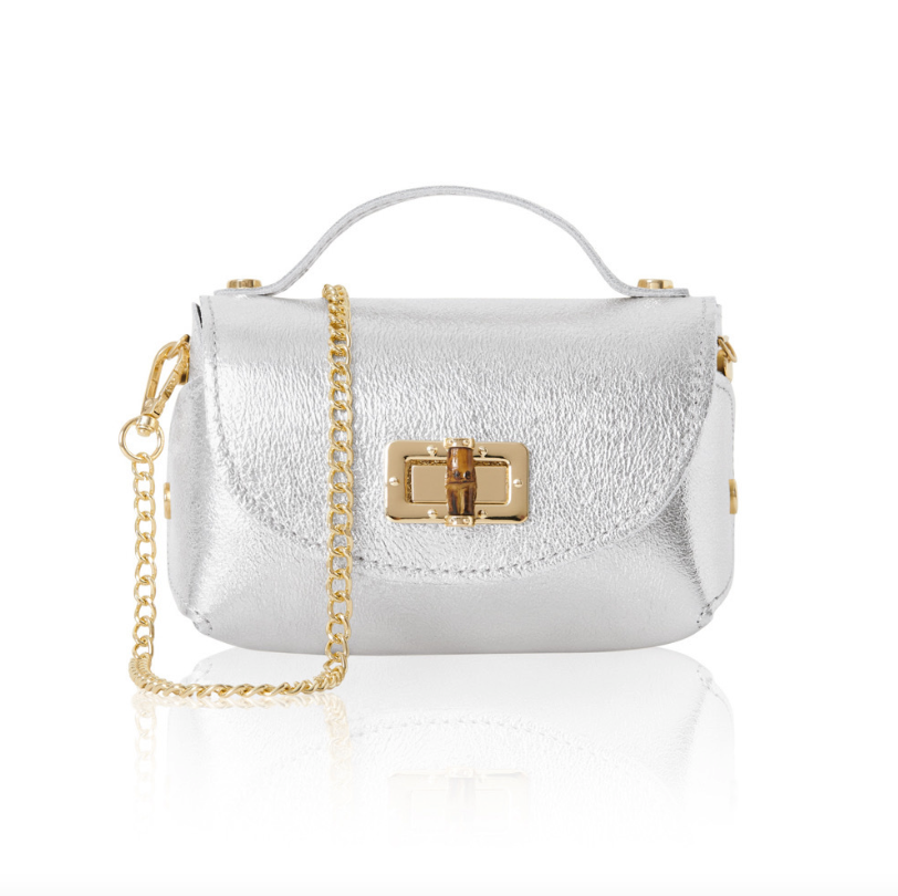 A small, structured silver leather handbag with a textured finish, featuring a gold turn-lock closure on the front flap, a short top handle, and a detachable gold chain shoulder strap. 